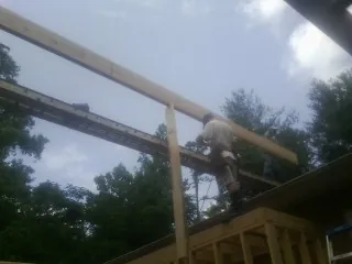 Carpenter setting a ridge beam over a new addition frame — Ice Dam Removal by Roofing Brothers in Bickleton